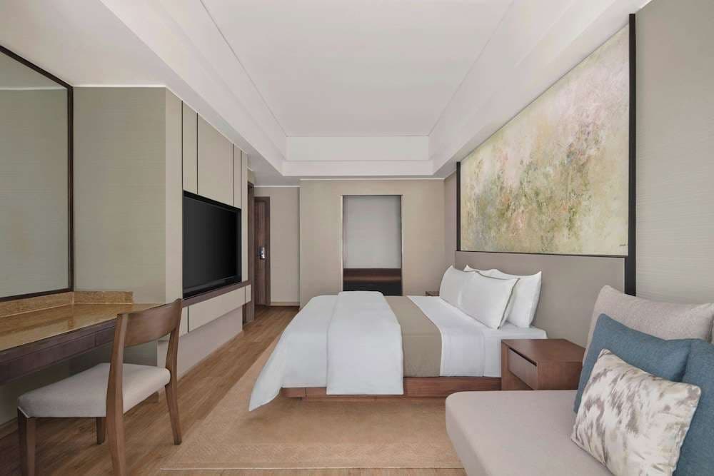 King bed with a work desk and framed artwork